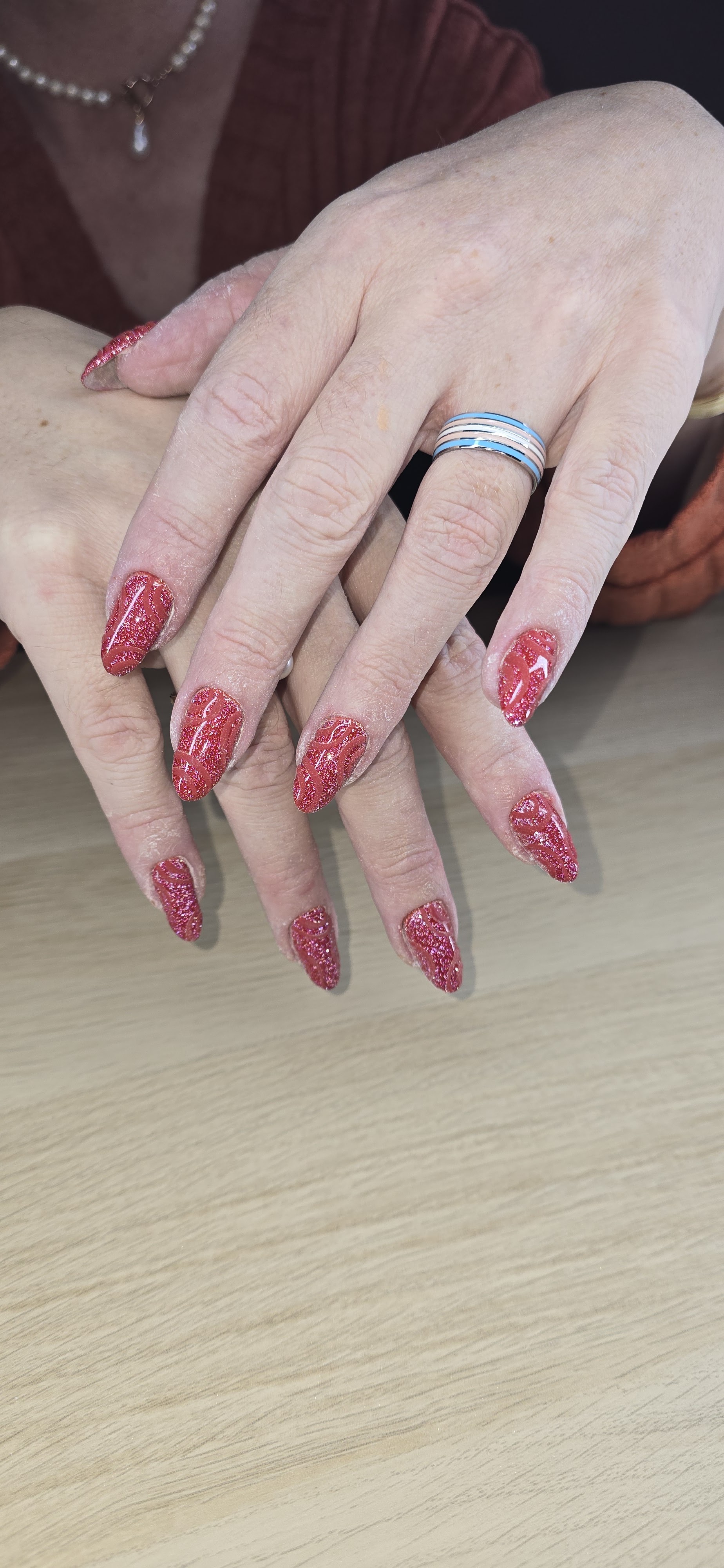 Gelnagels in rood met glans op een houten tafel
