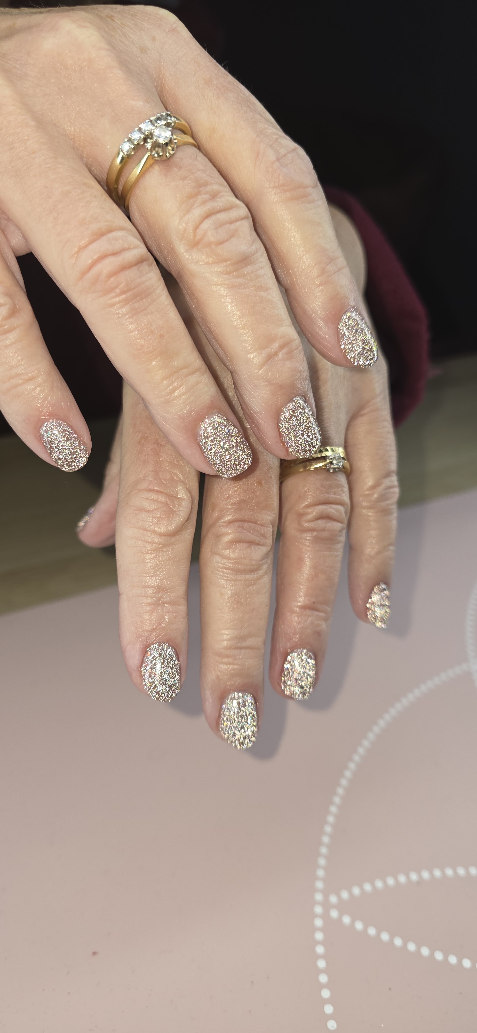 Nagels vol zilver- en goudglitter op twee handen