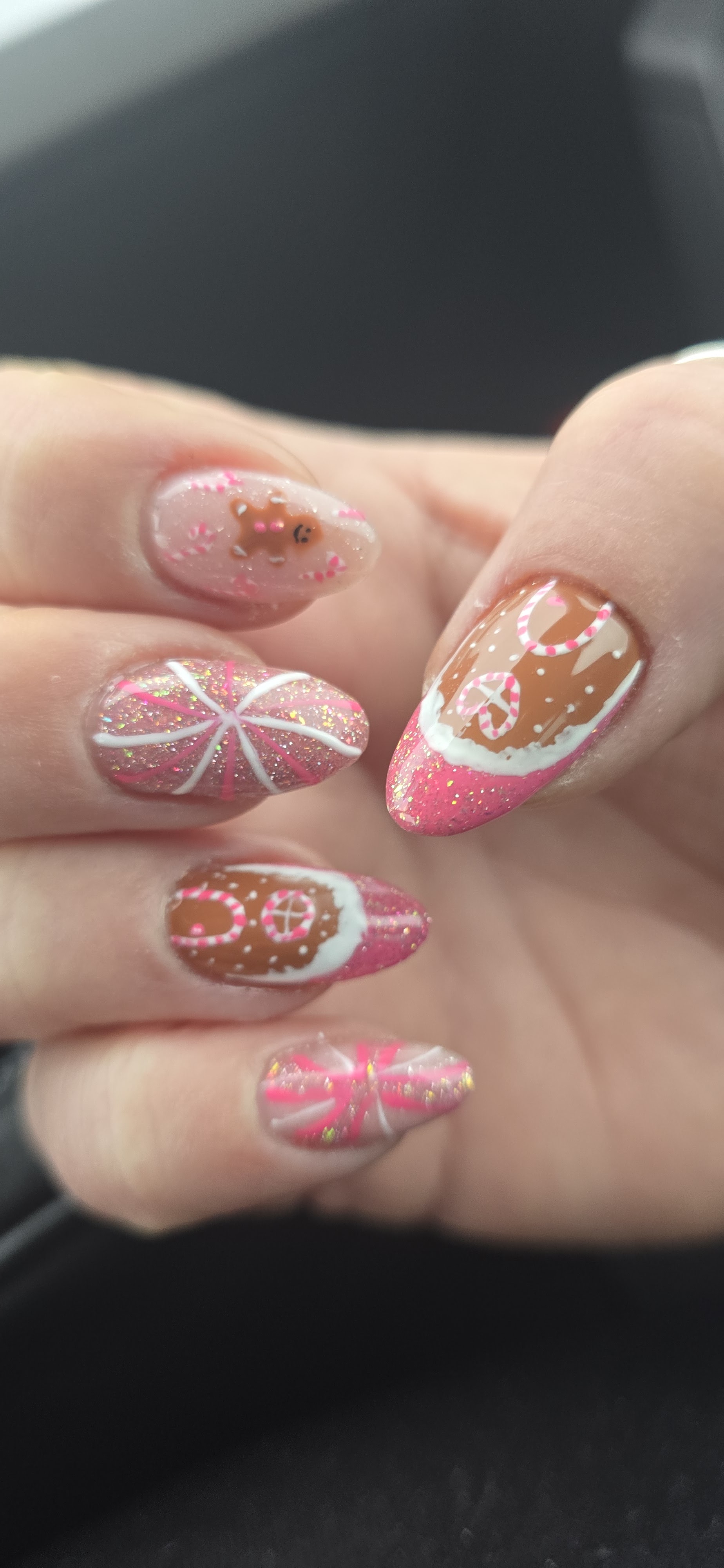 Nail art met peperkoek en zuurstokmotief in roze, wit en bruin