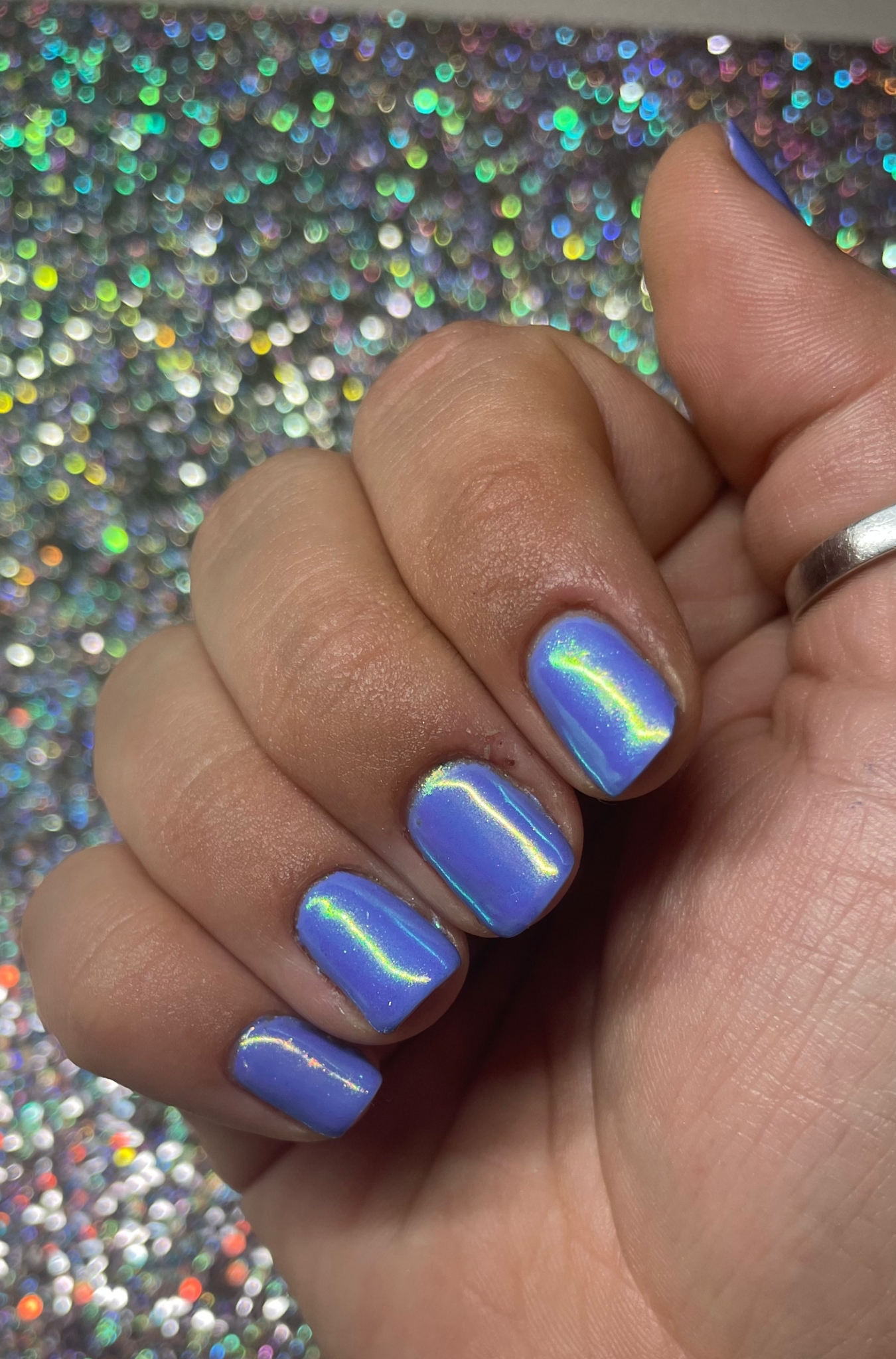 Lila chroomnagels boven een ondergrond vol glitter