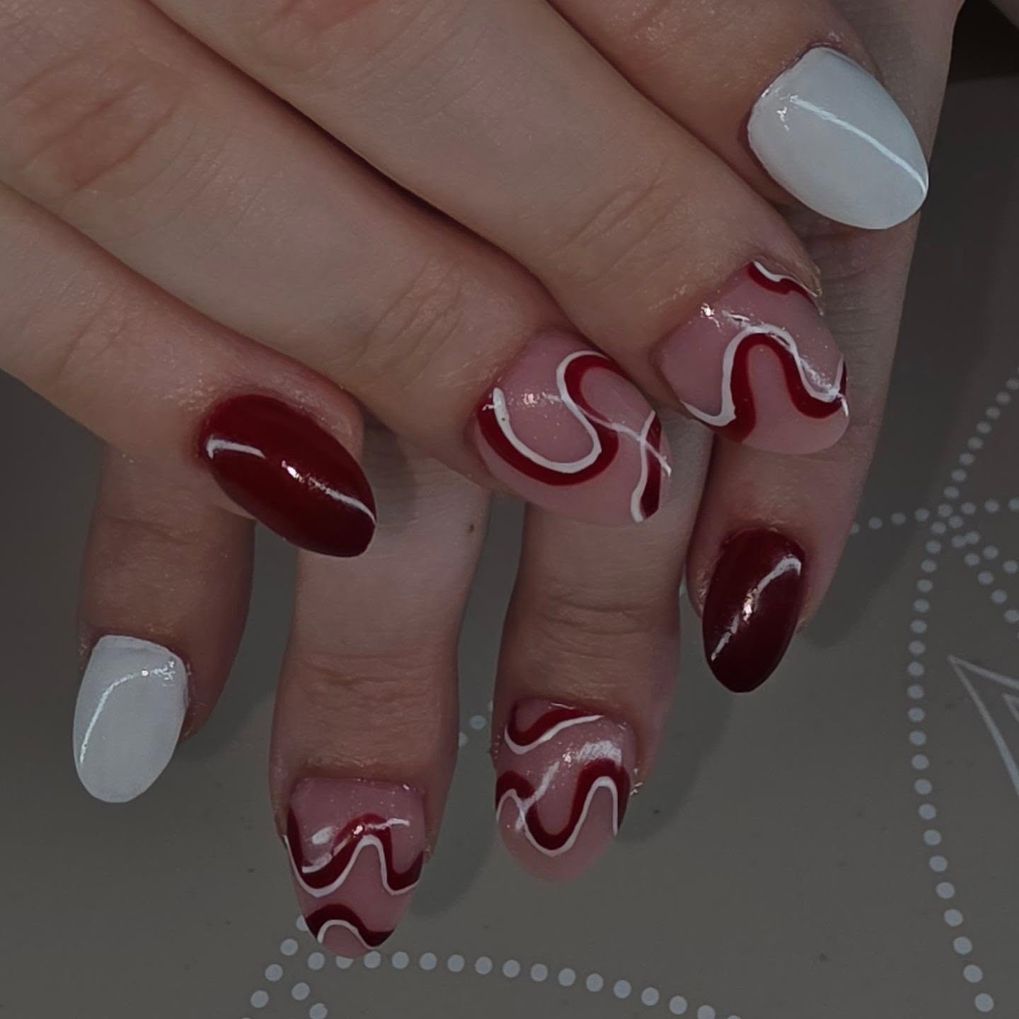 Nagels in bordeaux en wit met golvende lijnen